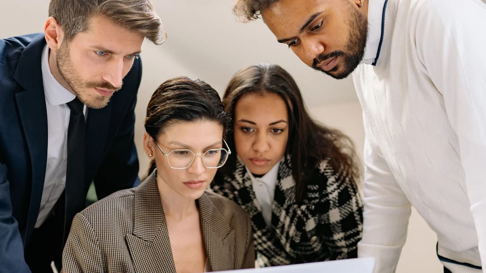 A small team collaborating around a laptop.